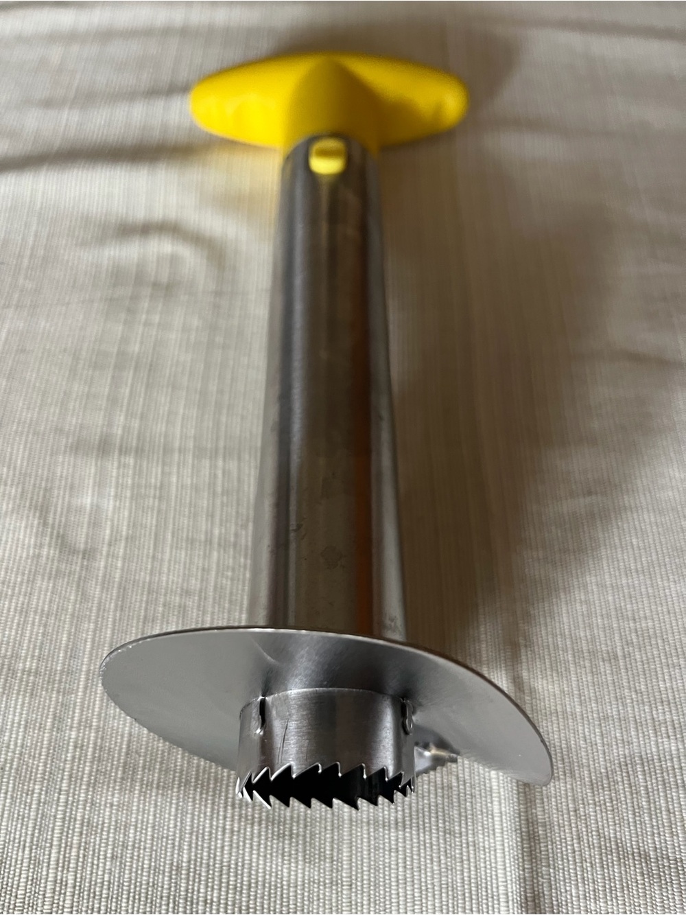 Stainless steel pineapple corer and slicer. Ergonomic yellow plastic handle for